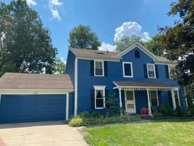 White window trim and navy shutters on refinished aluminum siding Westlake